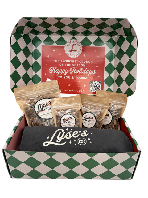 Inside of the holiday box with Lyse's snacks , apron and Glazed Pecans, on a white background